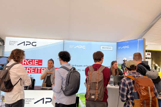 A crowd of people in front of an APG exhibition stand.